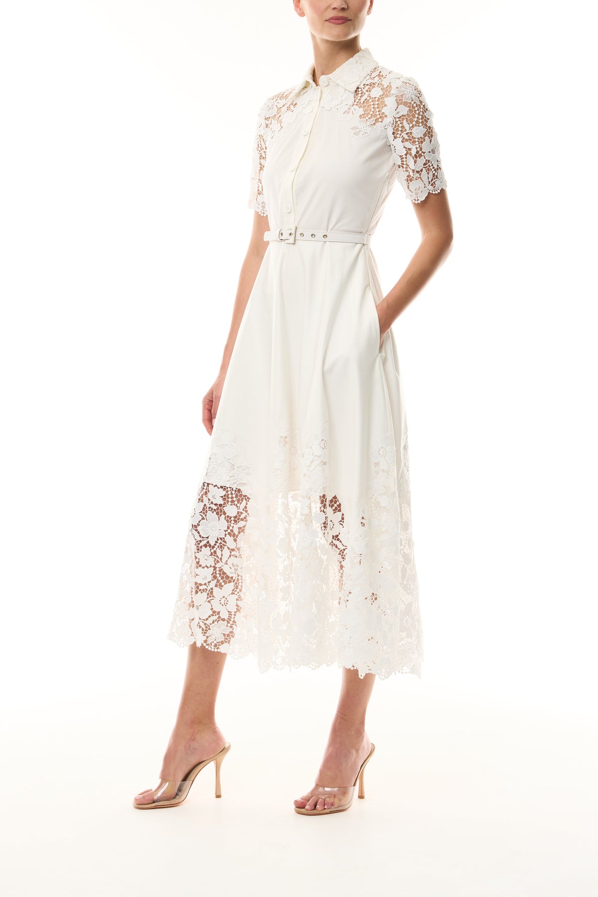 Monique Lhuillier Spring 2025 white cotton poplin dress with lace applique inserts, short sleeves, button down front bodice and belted waist - side.