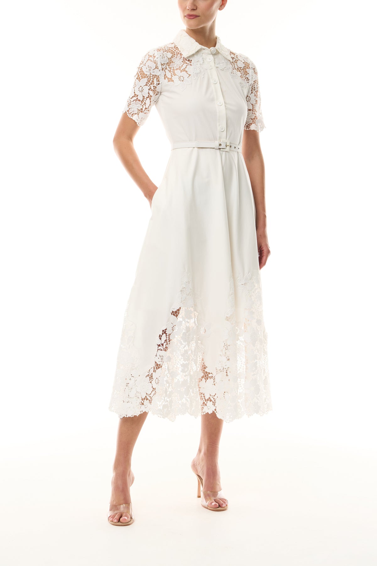 Monique Lhuillier Spring 2025 white cotton poplin dress with lace applique inserts, short sleeves, button down front bodice and belted waist - front.
